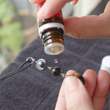 Adding a drop of essential oil to Tactile Necklace